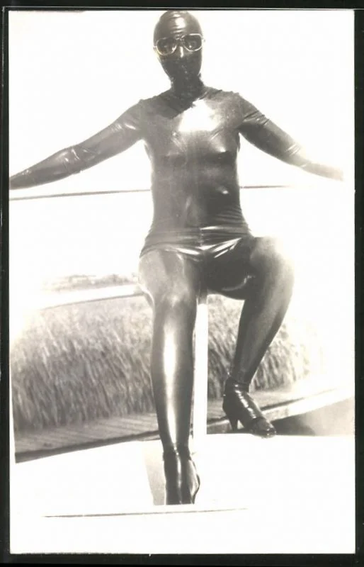Fotografie-Gummi-Fetisch-Frau-im-Ganzkoerper-Latexanzug-mit-Brille.webp