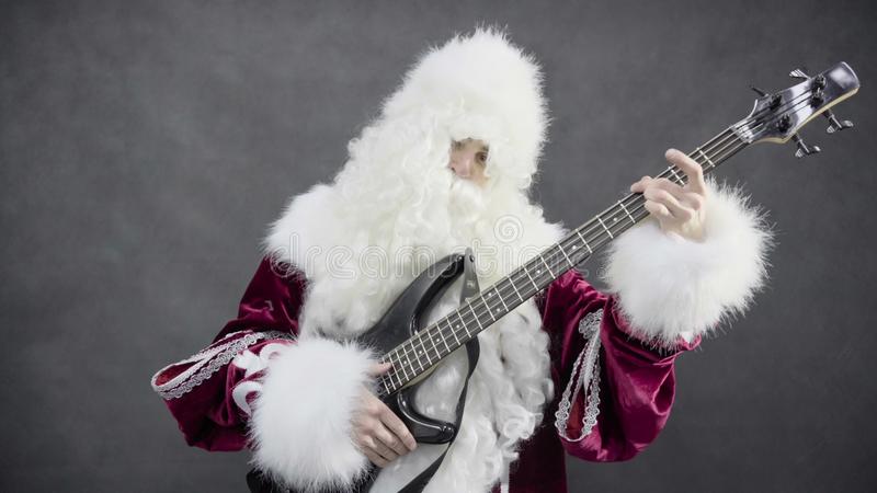 weihnachtsmann-spiele-der-weihnachtsmelodien-klingelglocken-auf-der-bass-gitarre-93894446.jpg