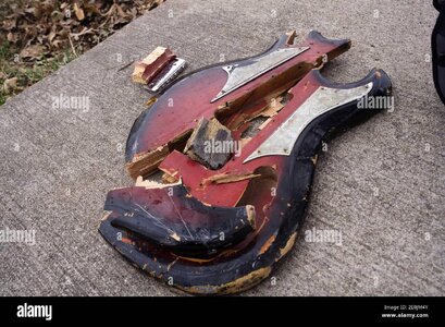die-stucke-einer-gebrochenen-roten-gitarre-liegen-zusammen-auf-rauem-beton-2e0jm4y.jpg